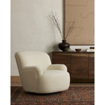 Kadon Natural Swivel Chair is a high wing back pairs with softly rolled arms for a curvy look and supportive sit. Cream-colored shearling-upholstered seating tops a 360-degree swivel. Amethyst Home provides interior design services, furniture, rugs, and lighting in the Austin metro area.