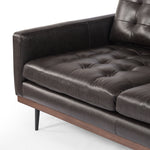 Low-leaning style with mid-century vibes. Upholstered in an exclusive subtly distressed black top-grain leather, with button tufting for texture and comfort. Finished with wrap-around framing and cone-tapered legs. Amethyst Home provides interior design, new construction, custom furniture, and area rugs in the Newport Beach metro area.