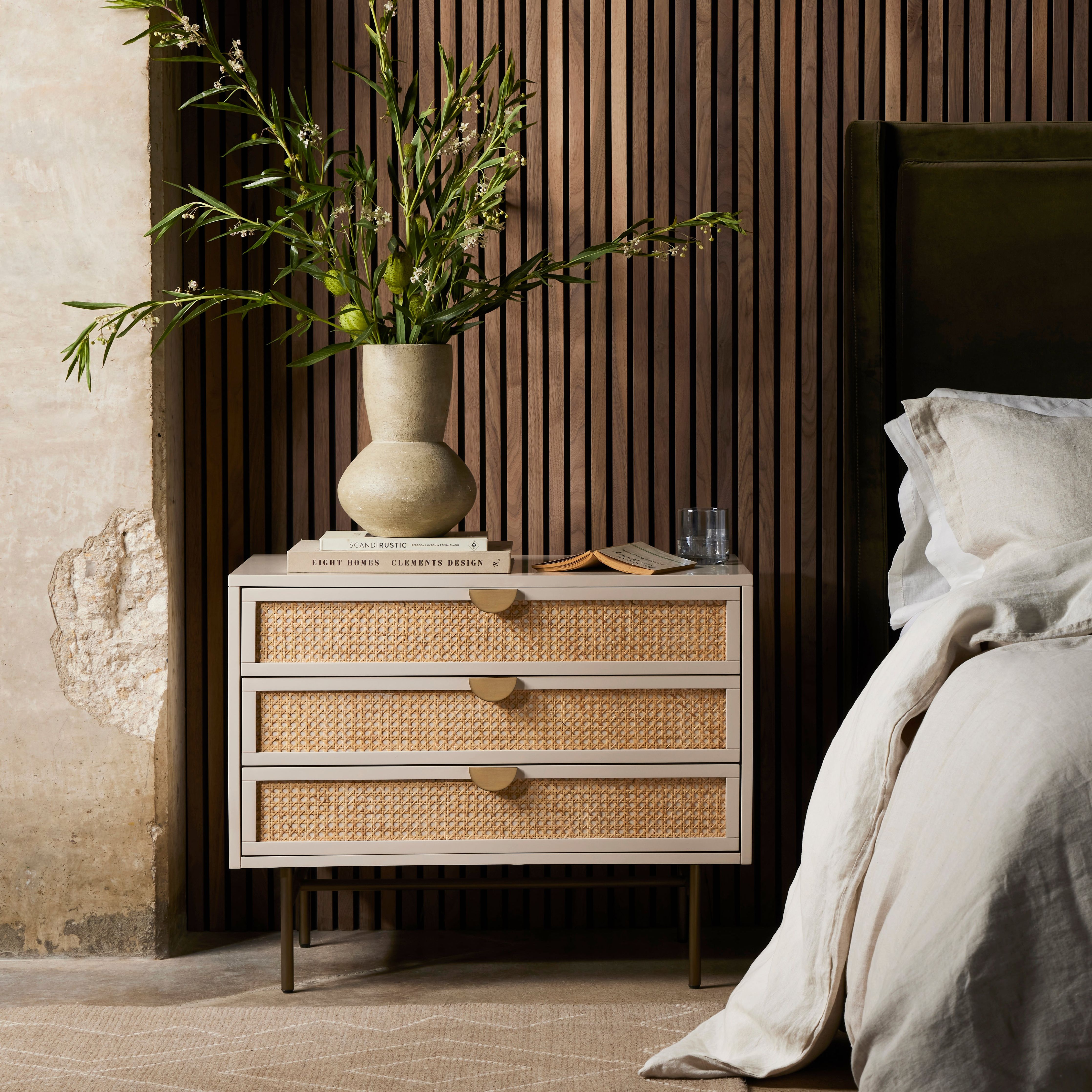 Bring a light, textural look to bedside storage. A lacquered three-drawer nightstand features woven cane panels and half-moon hardware finished in an aged brass. Amethyst Home provides interior design, new construction, custom furniture, and area rugs in the Austin metro area.