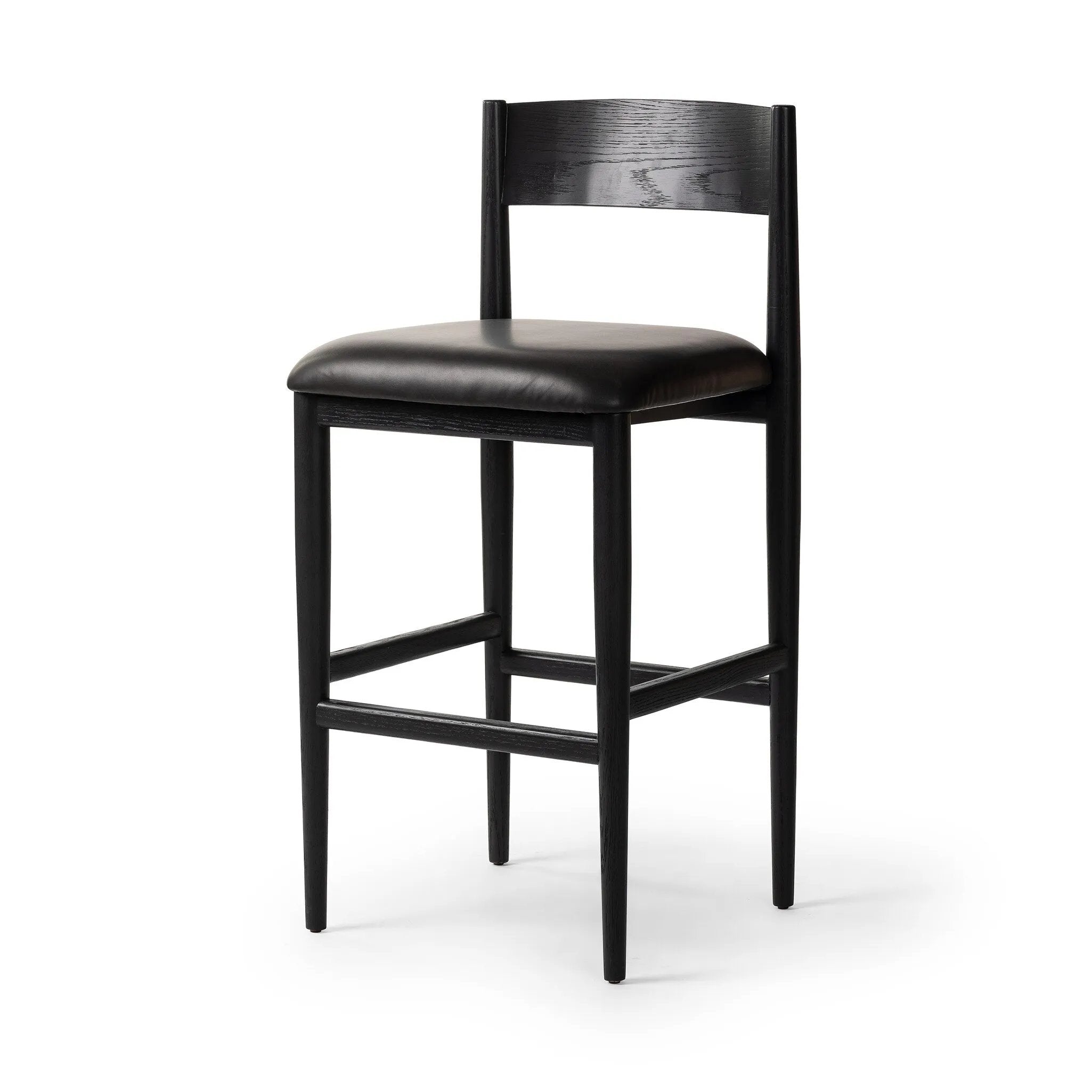 Monochromatic meets midcentury with this bar-height stool. Structured while comfortable, the tapered-leg chair pairs an ebony wood frame with a faux leather cushion.Collection: Ashfor Amethyst Home provides interior design, new home construction design consulting, vintage area rugs, and lighting in the Charlotte metro area.