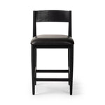 Monochromatic meets midcentury with this counter-height stool. Structured while comfortable, the tapered-leg chair pairs an ebony wood frame with a faux leather cushion.Collection: Ashfor Amethyst Home provides interior design, new home construction design consulting, vintage area rugs, and lighting in the Omaha metro area.