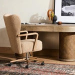 A comfort-driven desk chair features soft, textural upholstery in a versatile camel, framed by solid ash arms. A height-adjustable swivel base with casters makes for ease in the modern office. Amethyst Home provides interior design, new home construction design consulting, vintage area rugs, and lighting in the Washington metro area.