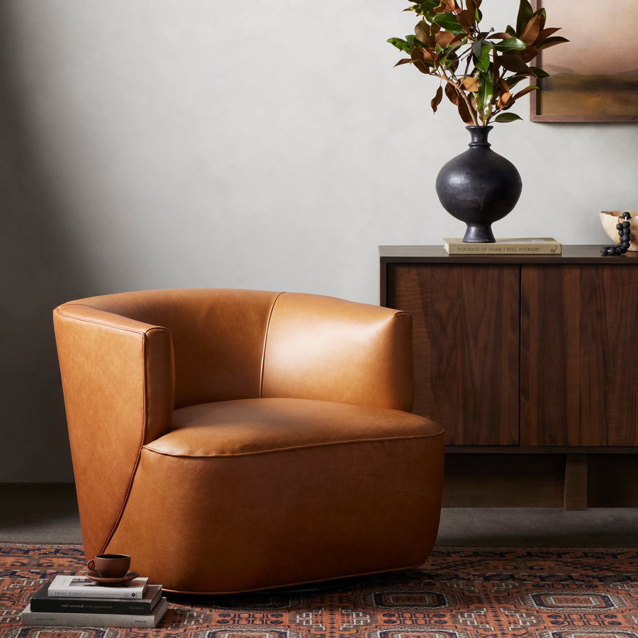 Supple, camel-colored top-grain leather hugs the curves of this modern-shaped seat, featuring a hidden 360-degree swivel. Amethyst Home provides interior design, new construction, custom furniture, and area rugs in the Omaha metro area.