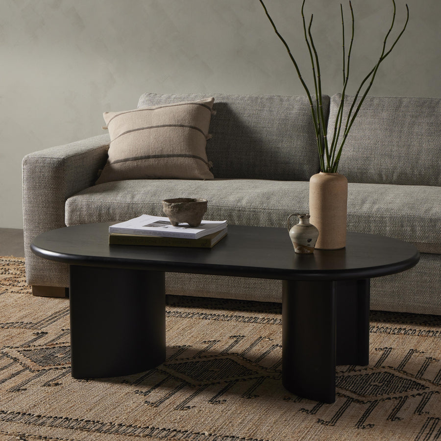 A study in shape. Black acacia forms crescent-shaped legs and sprawling oval tabletop, bringing organic presence to the living room. Amethyst Home provides interior design, new home construction design consulting, vintage area rugs, and lighting in the Portland metro area.