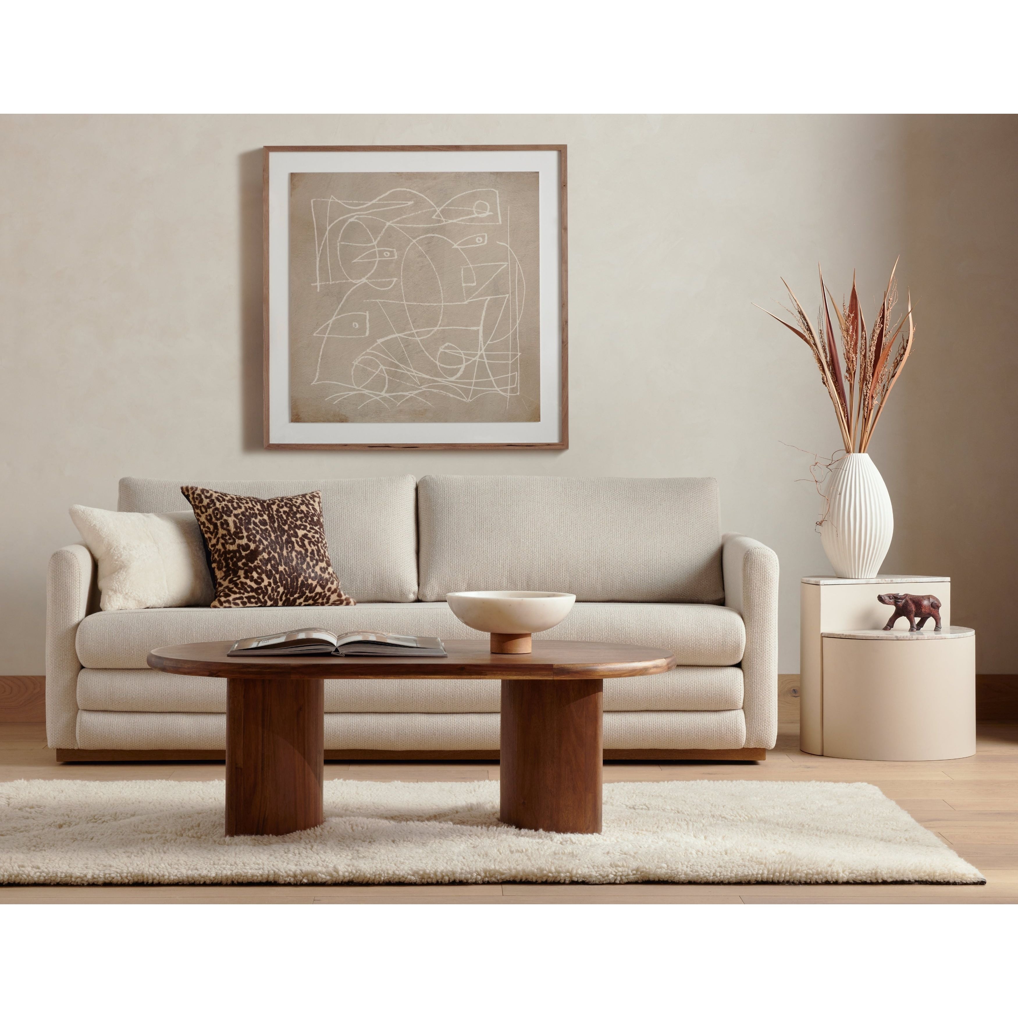 A study in shape. Solid brown acacia forms crescent-shaped legs and sprawling oval tabletop, bringing organic presence to the living room. Amethyst Home provides interior design, new construction, custom furniture and area rugs in the Calabasas metro area