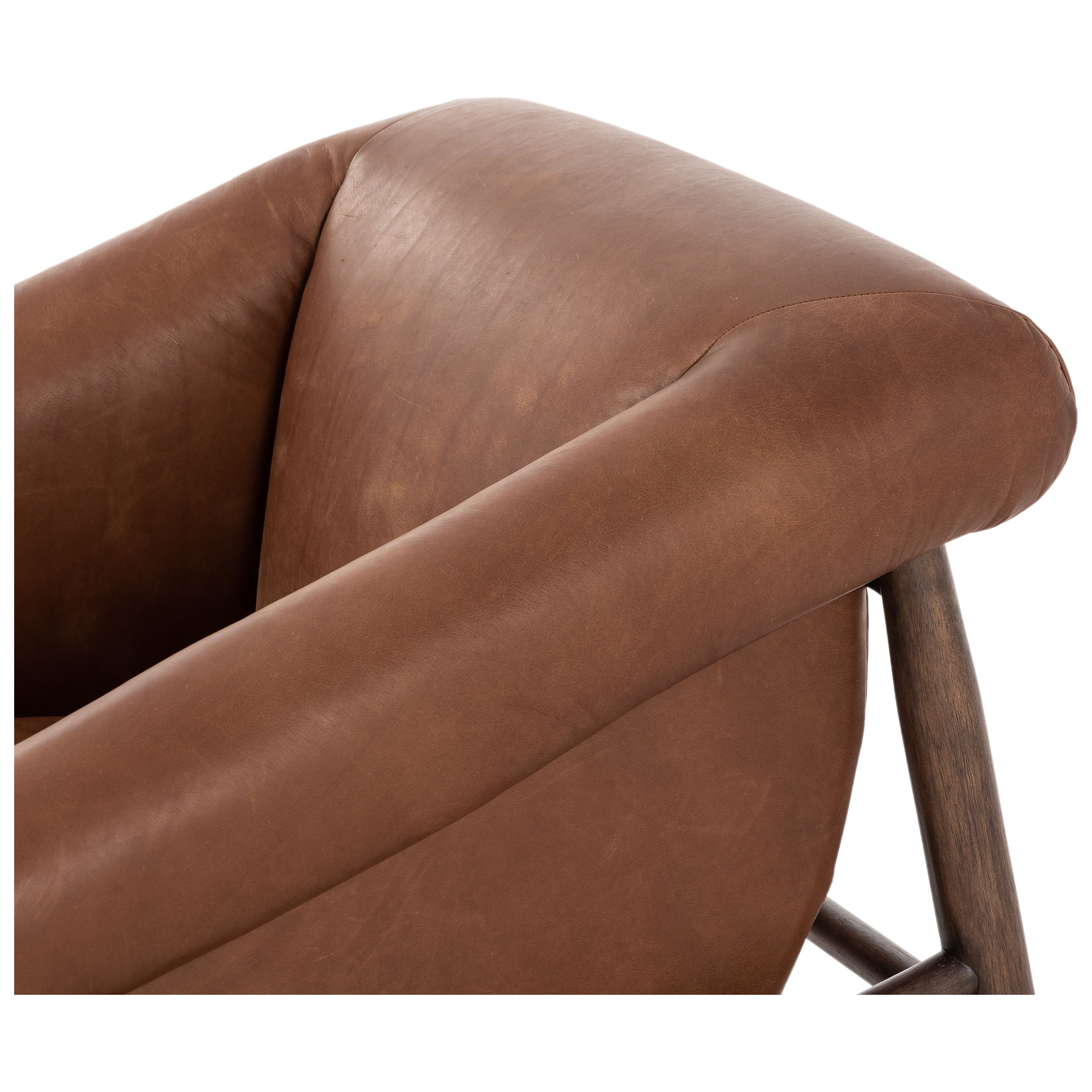 Featuring Reggie Heirloom Sienna Chair by Four Hands at Amethyst Home. Oversized cushioning brings a Brazilian midcentury feel to this vintage-inspired chair. Designed with cushion-wrapped slanted arms, fixed cushioning with a deep sit and narrow legs reminiscent of midcentury style. Sourced from one of the oldest family-owned tanneries in Italy's Bassano del Grappa, heirloom leather. Amethyst Home provides interior design, new construction, custom furniture, and area rugs in the Tampa metro area.