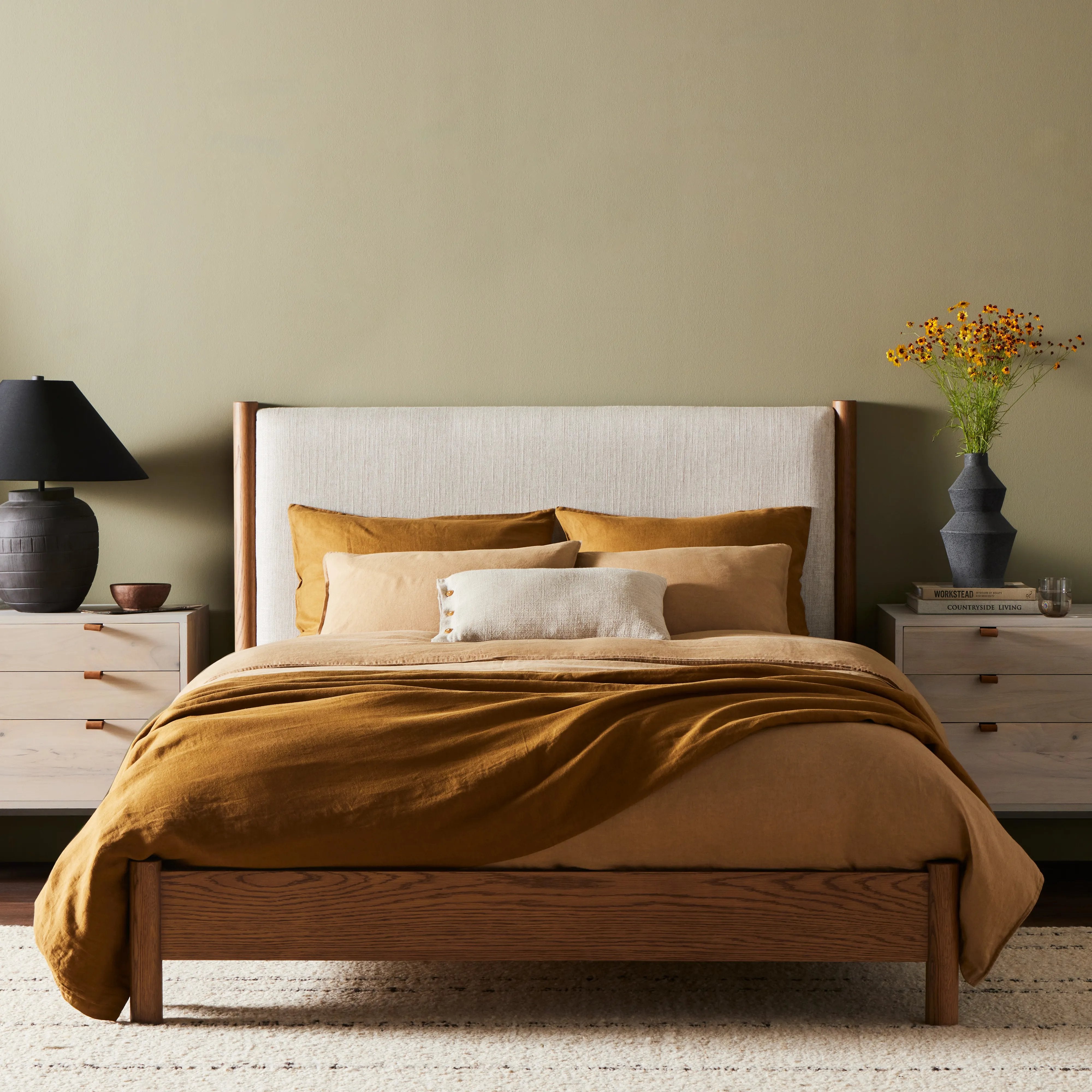 Rounded, chunky dowel legs in an amber oak finish frame the neutral, linen-like upholstered headboard of this bed frame.Collection: Bolto Amethyst Home provides interior design, new home construction design consulting, vintage area rugs, and lighting in the Des Moines metro area.