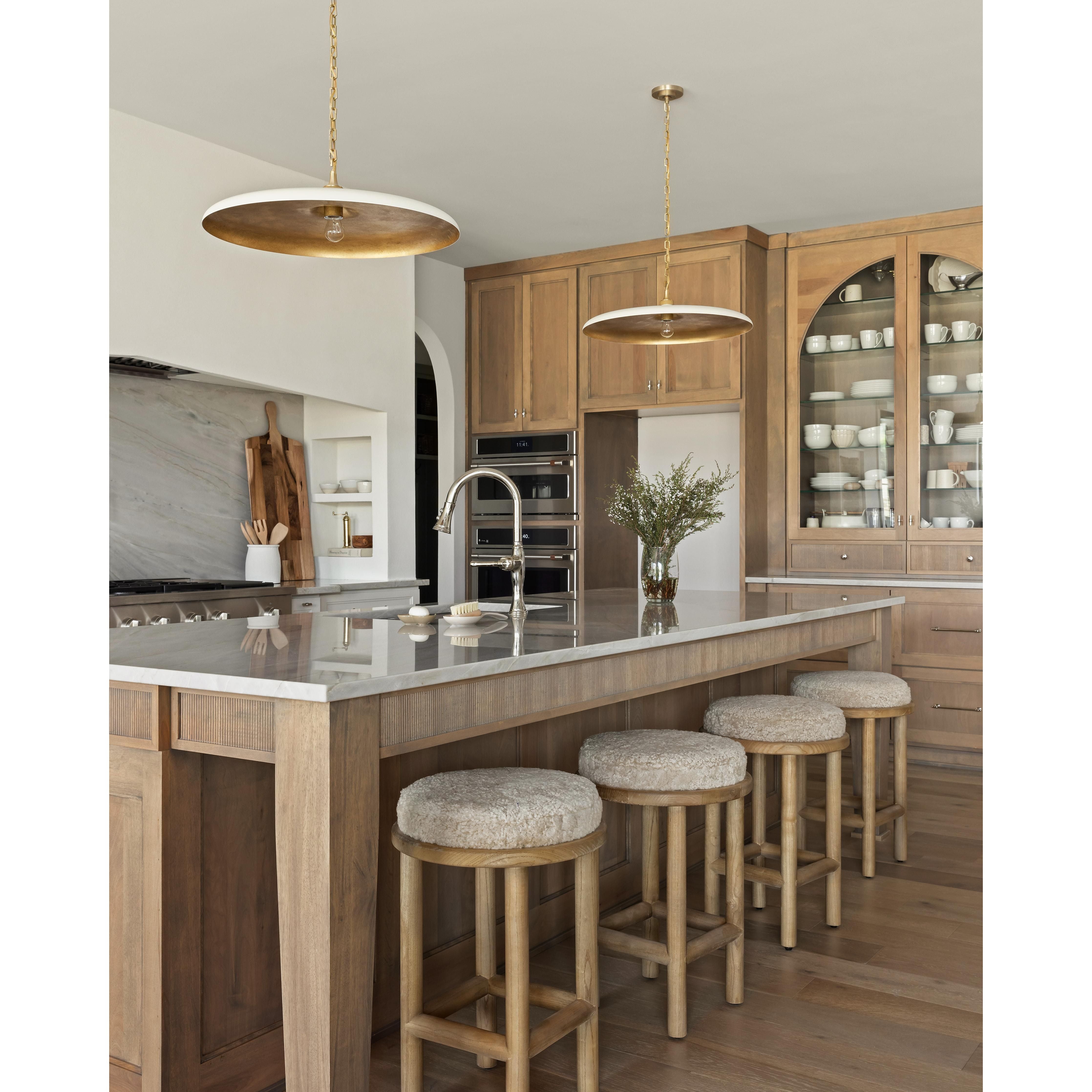 Introducing the Saldino Stool, the perfect addition to any modern coastal kitchen. With its blonde-finished solid parawood frame and soft beige shearling seat, this stool offers both comfort and style. Featuring reeded cabinet details, quarter sawn white oak cabinets, and an arched kitchen hutch, it seamlessly blends with any kitchen design.