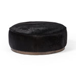 This large, round ottoman of textural hair-on hide brings with it a hip retro vibe as a coffee table or extra seating.  Covered in soft and luminous black hair-on hide, which is naturally warm and textural with authentic highlights. Amethyst Home provides interior design, new construction, custom furniture, and area rugs in the Austin metro area.
