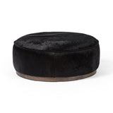 This large, round ottoman of textural hair-on hide brings with it a hip retro vibe as a coffee table or extra seating.  Covered in soft and luminous black hair-on hide, which is naturally warm and textural with authentic highlights. Amethyst Home provides interior design, new construction, custom furniture, and area rugs in the Austin metro area.