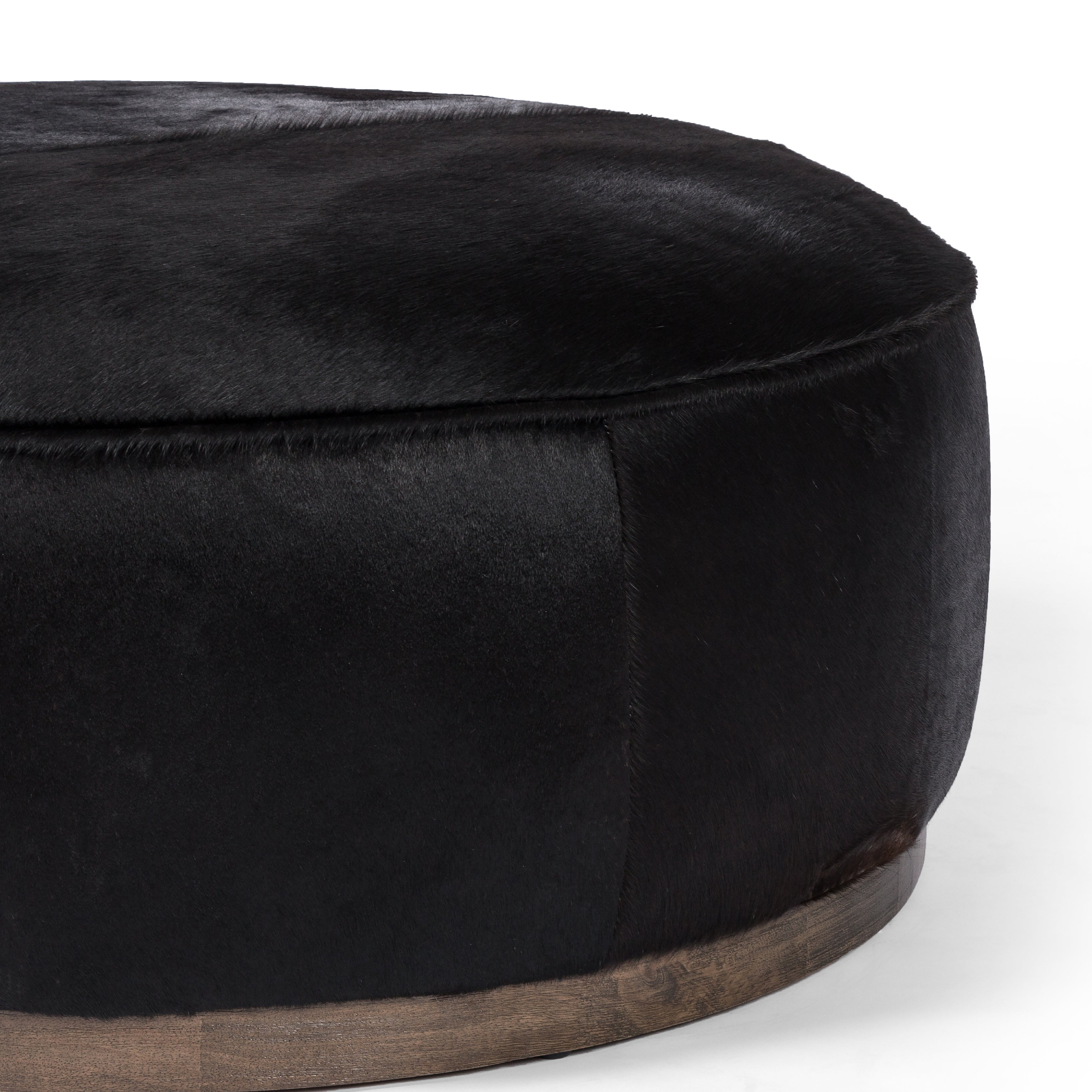 This large, round ottoman of textural hair-on hide brings with it a hip retro vibe as a coffee table or extra seating.  Covered in soft and luminous black hair-on hide, which is naturally warm and textural with authentic highlights. Amethyst Home provides interior design, new construction, custom furniture, and area rugs in the Charlotte metro area.