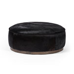 This large, round ottoman of textural hair-on hide brings with it a hip retro vibe as a coffee table or extra seating.  Covered in soft and luminous black hair-on hide, which is naturally warm and textural with authentic highlights. Amethyst Home provides interior design, new construction, custom furniture, and area rugs in the Laguna Beach metro area.