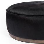 This large, round ottoman of textural hair-on hide brings with it a hip retro vibe as a coffee table or extra seating.  Covered in soft and luminous black hair-on hide, which is naturally warm and textural with authentic highlights. Amethyst Home provides interior design, new construction, custom furniture, and area rugs in the Monterey metro area.