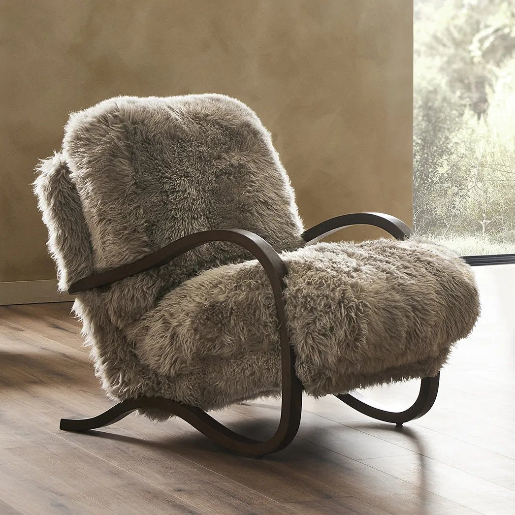 Ethically sourced authentic Mongolian sheepskin covers this unique statement chair, featuring removable feather-foam cushions. A cantilever-like wooden frame pairs with a webbed suspension seat to offer a true sink-in sit Amethyst Home provides interior design, new home construction design consulting, vintage area rugs, and lighting in the Omaha metro area.