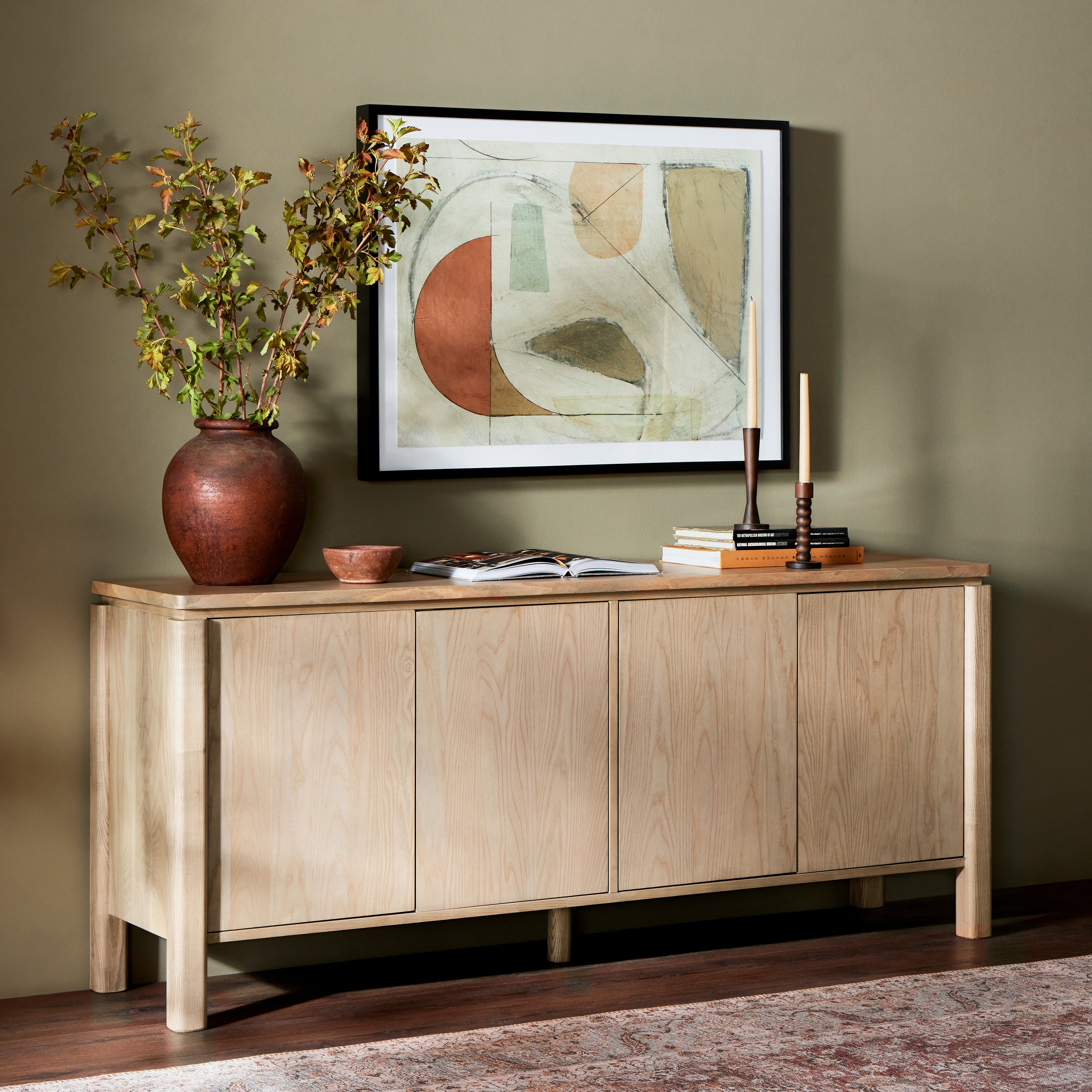Large, rounded legs support this sleek sideboard with a reveal detail at the top. A beautiful ash finish showcases and highlights the natural wood grain. Amethyst Home provides interior design, new construction, custom furniture, and area rugs in the Omaha metro area.