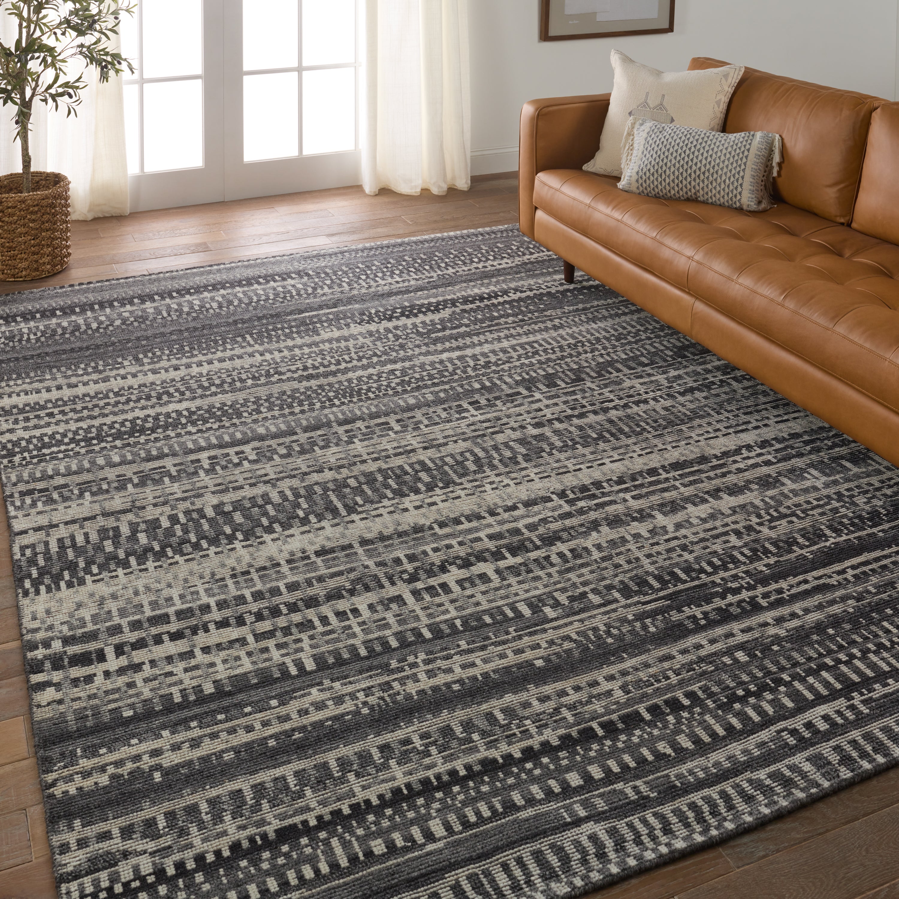 The Rize collection offers intricate and delicately designed global patterns to the modern home. The luxurious Jamaal area rug showcases a striped, linear motif in a classic gray, cream, and black colorway. This accent's hand-knotted wool construction ensures timeless durability and a stunning presence in bohemian spaces.  Amethyst Home provides interior design, new construction, custom furniture, and area rugs in the Laguna Beach metro area.
