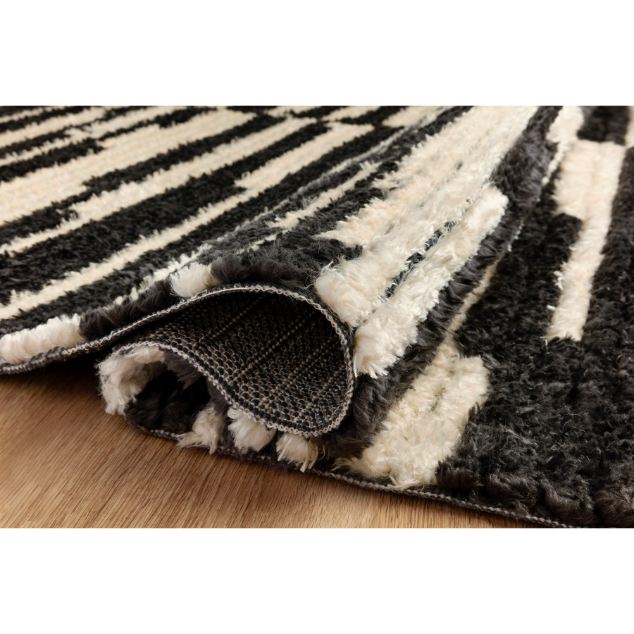 Durable, graphic, and soft underfoot, this rug is inspired by the classic Moroccan rug. The Alice Chris + Julia Cream / Charcoal ALI-03 rug features a high-low texture with warm earthy colors with a subtle fringe. The rug is easy to clean and maintain and perfect for living rooms, dining rooms, hallways, and kitchens!
