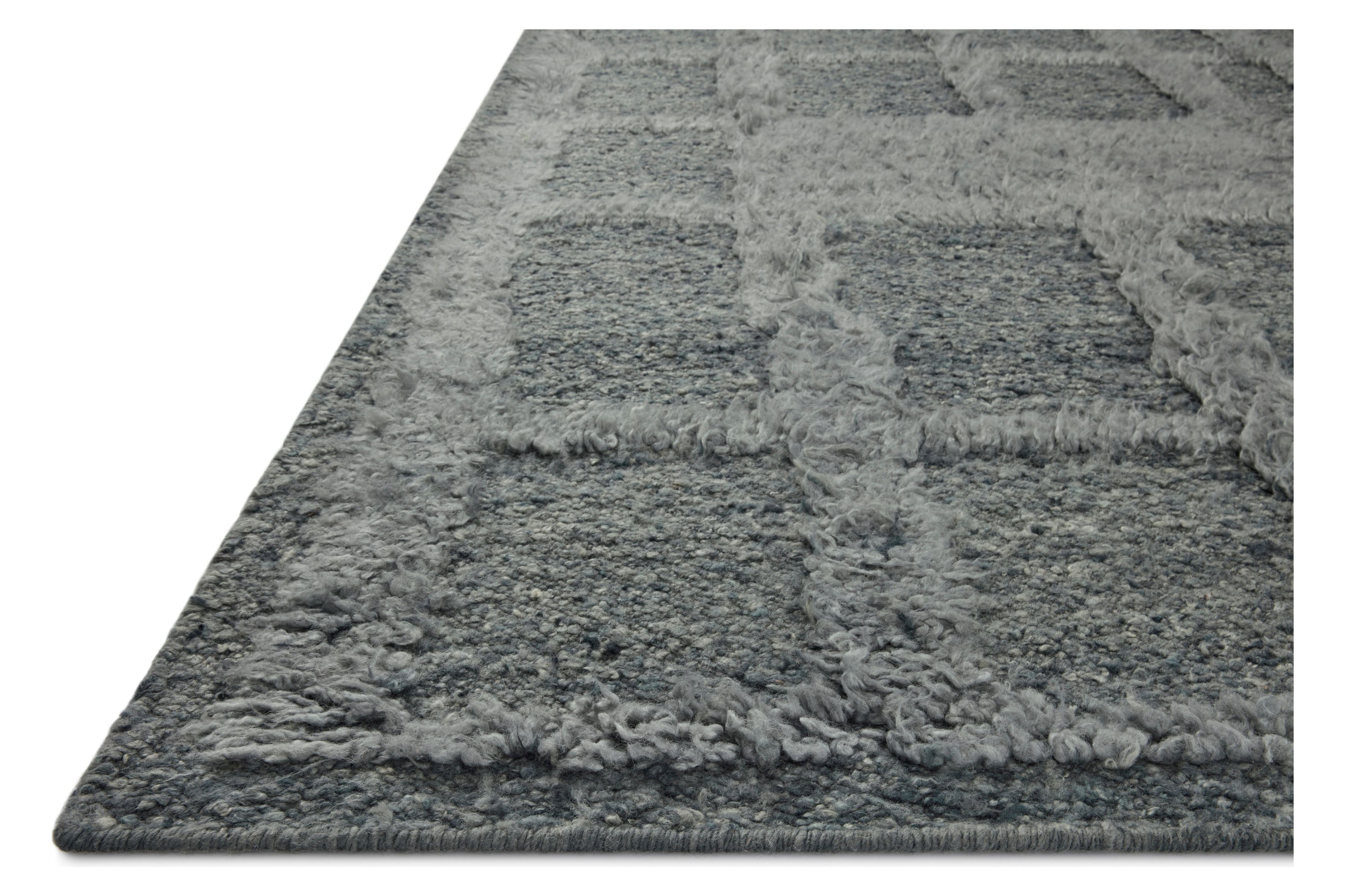 The Cassian Denim rug is a hand-woven wool and cotton area rug with an asymmetrical gridded pattern and high-low texture. The rug’s higher, shaggy pile takes cues from Moroccan designs, while the neutral colors and natural materials make it a cozy addition to any space, especially living rooms and dens. Amethyst Home provides interior design, new home construction design consulting, vintage area rugs, and lighting in the Des Moines metro area.