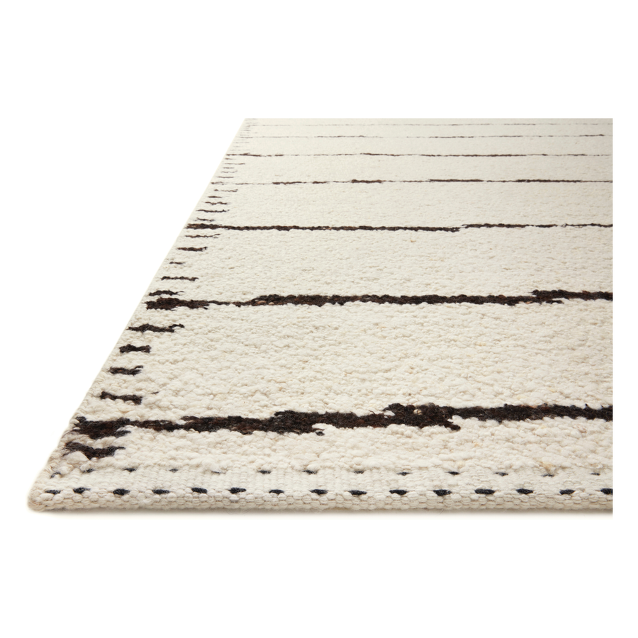 A perfect blend of refined and relaxed, the Roman Ivory / Black ROM-05 rug from Loloi is hand woven of wool, cotton and viscose by skilled artisans. Designs with meticulously placed strokes elevate any area such as an entryway, living room, dining room, or bedroom. Each piece is finished with a unique stitched edge. Amethyst Home provides interior design, new construction, custom furniture, and rugs for the Austin, Houston, and Dallas, Texas metro area.