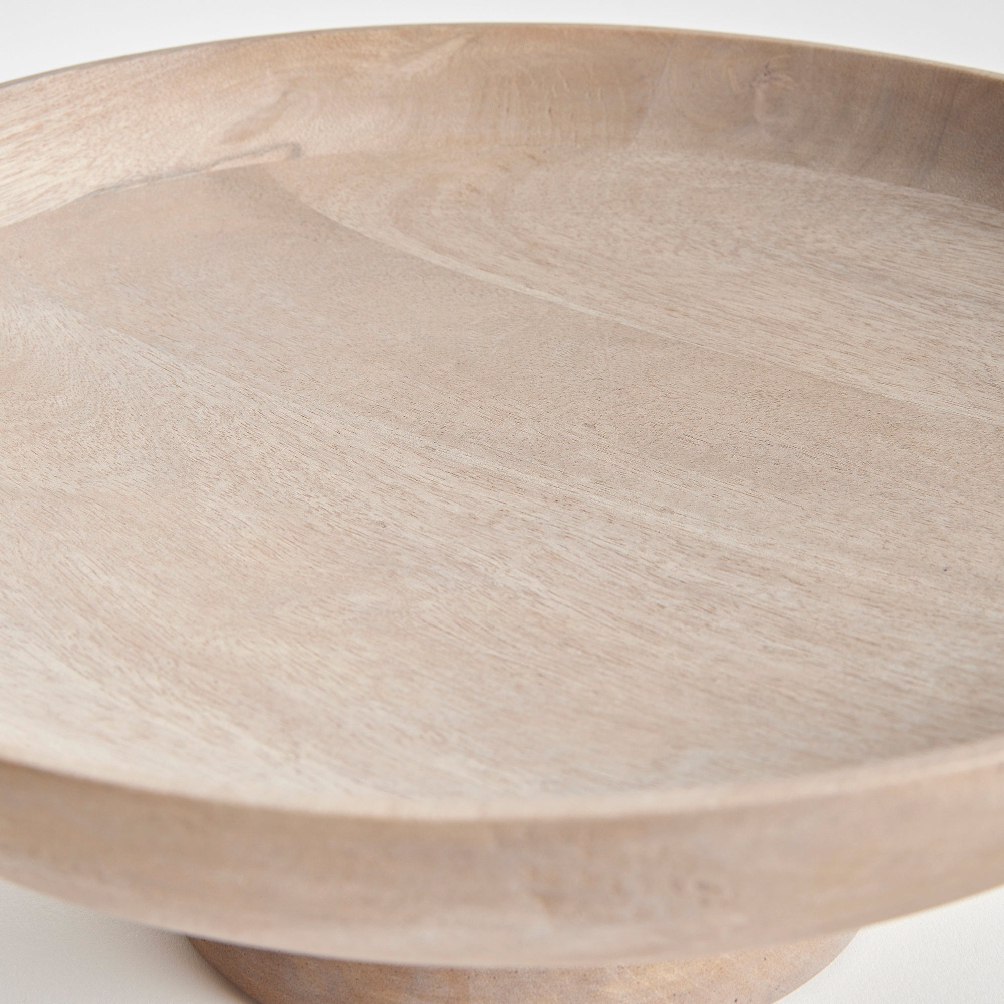 Contemporary and uniquely designed, this footed bowl is made of mango wood. Makes a beautiful serving bowl for dry foods, as well as a gorgeous centerpiece all on its own. Amethyst Home provides interior design, new construction, custom furniture, and area rugs in the Los Angeles metro area.