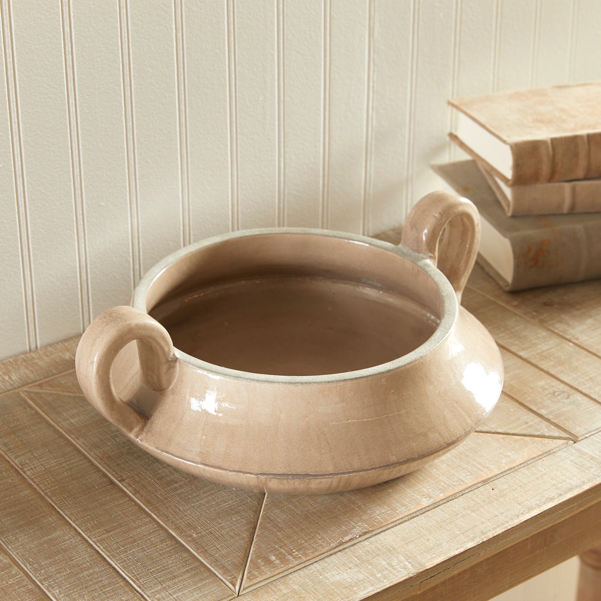 This vintage-inspired perfectly taupe bowl is not short on character and charm. From the unique shape, to the elevated loop handles and artistically uneven glaze, it makes a beautiful accent for kitchen or dining room. Amethyst Home provides interior design, new construction, custom furniture, and area rugs in the Newport Beach metro area.