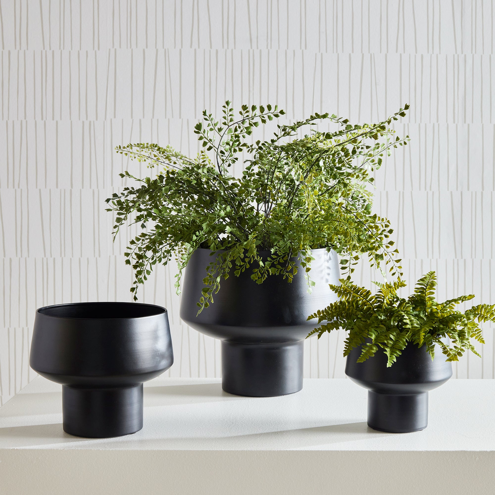 You'd never guess this set of three sleek cachepots are made of a light aluminum. Finished in a matte black, they are a contemporary set for your favorite faux ferns or floral drop-ins. Amethyst Home provides interior design, new construction, custom furniture, and area rugs in the Winter Garden metro area.