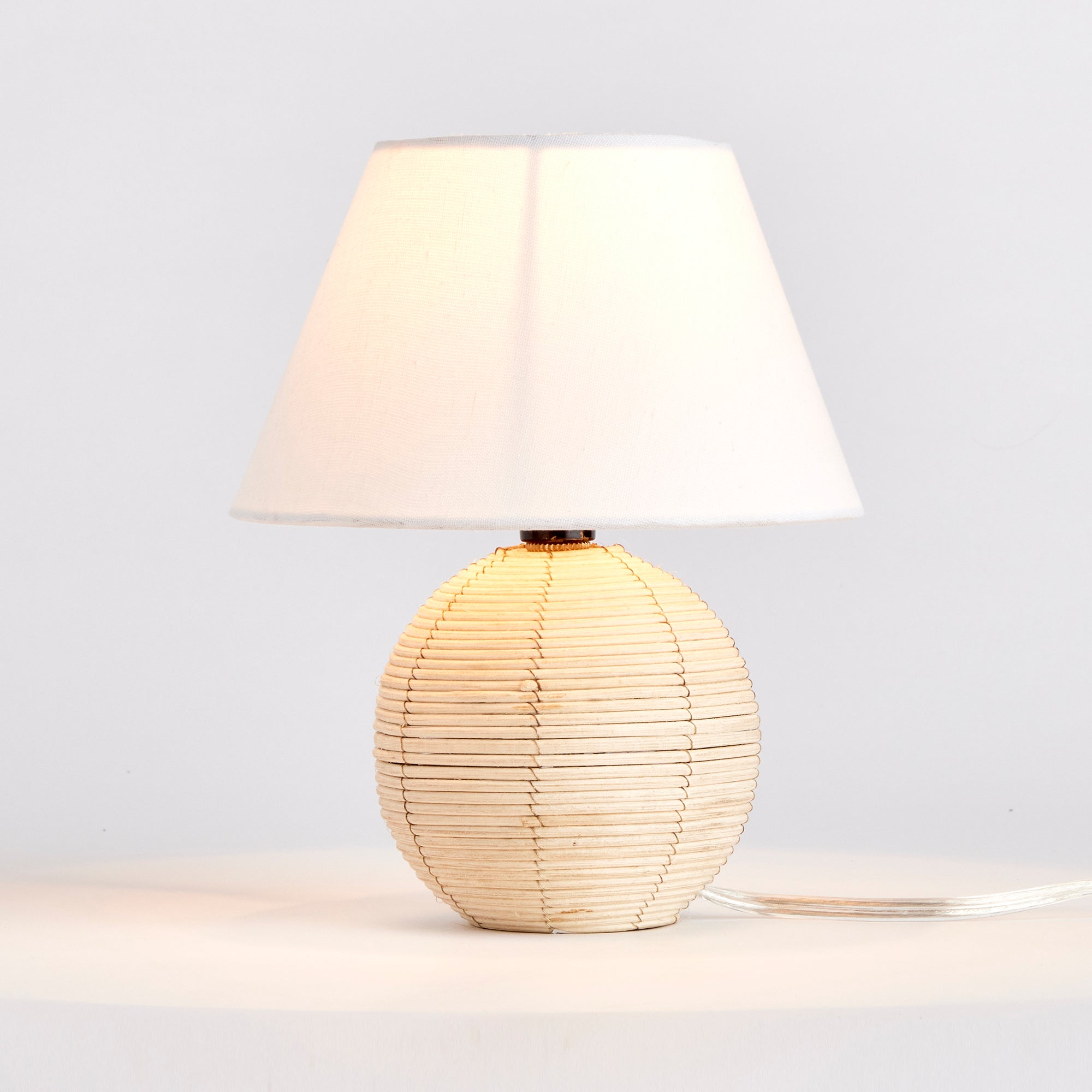 Woven in a natural cane rattan, with subtle variations in color making each one truly unique, this mini lamp is an instant classic. The petite shape and tailored shade make it the ideal lamp for kitchen counter or small workspace. Amethyst Home provides interior design, new construction, custom furniture, and area rugs in the Portland metro area.