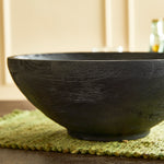 Serve up your best salad in this handcrafted serving bowl. Made of a solid mango wood and stained a dramatic deep black, it is a stunning vessel for your favorite recipes. Amethyst Home provides interior design, new construction, custom furniture, and area rugs in the Laguna Beach metro area.