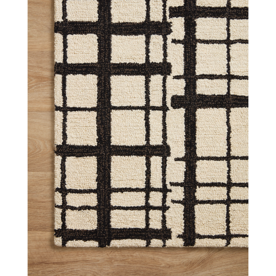 Hand-tufted of wool and jute pile, the Polly POL-02 CJ Black / Ivory rug for Chris Loves Julia x Loloi brings a fresh take on modern yet classic designs. With striking gridded designs toned down by a neutral color palette, Polly is a timeless choice for any room. Amethyst Home provides interior design, new construction, custom furniture, and rugs for the Winter Park metro area.