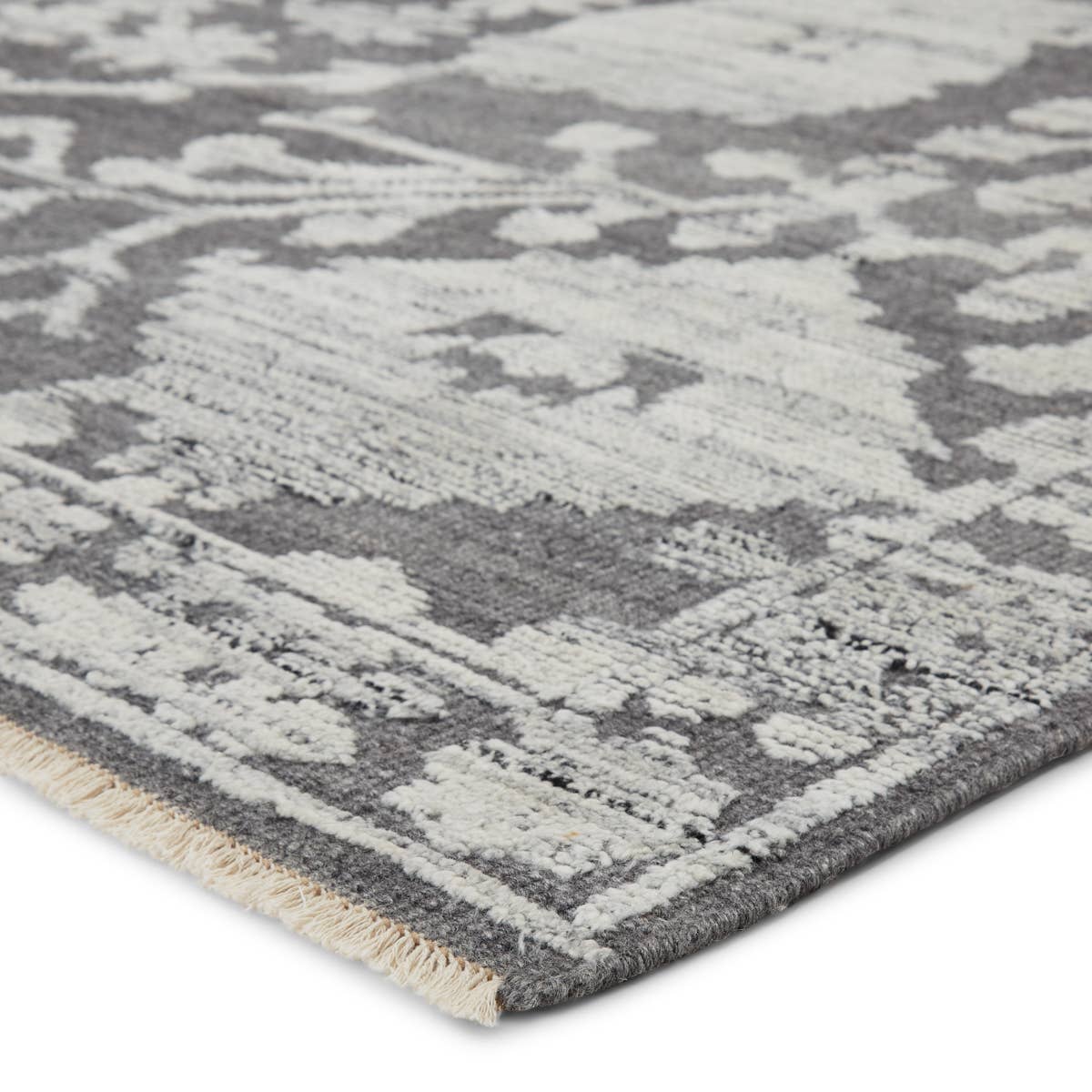 The Sonnette Riona Area Rug by Jaipur Living, or SNN01, boasts a high-contrast gray and silver palette that creates dimension among the florette medallion design. This hand-knotted wool rug features fringe trimmed details for a touch of global charm. A gorgeous choice for your bedroom or other medium traffic areas. 