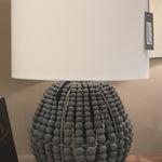 Coastal style meets modern charm with the Tropez table lamp. A bevy of draped charcoal grey wooden beads, dresses up the steel structure, bringing out an earthy glamour to a living room, dining room or bedroom.  Dimensions: 19"W x 19"D x 27.5"H 