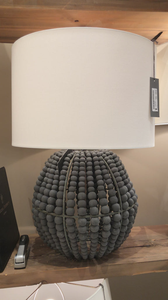 Coastal style meets modern charm with the Tropez table lamp. A bevy of draped charcoal grey wooden beads, dresses up the steel structure, bringing out an earthy glamour to a living room, dining room or bedroom.  Dimensions: 19"W x 19"D x 27.5"H 