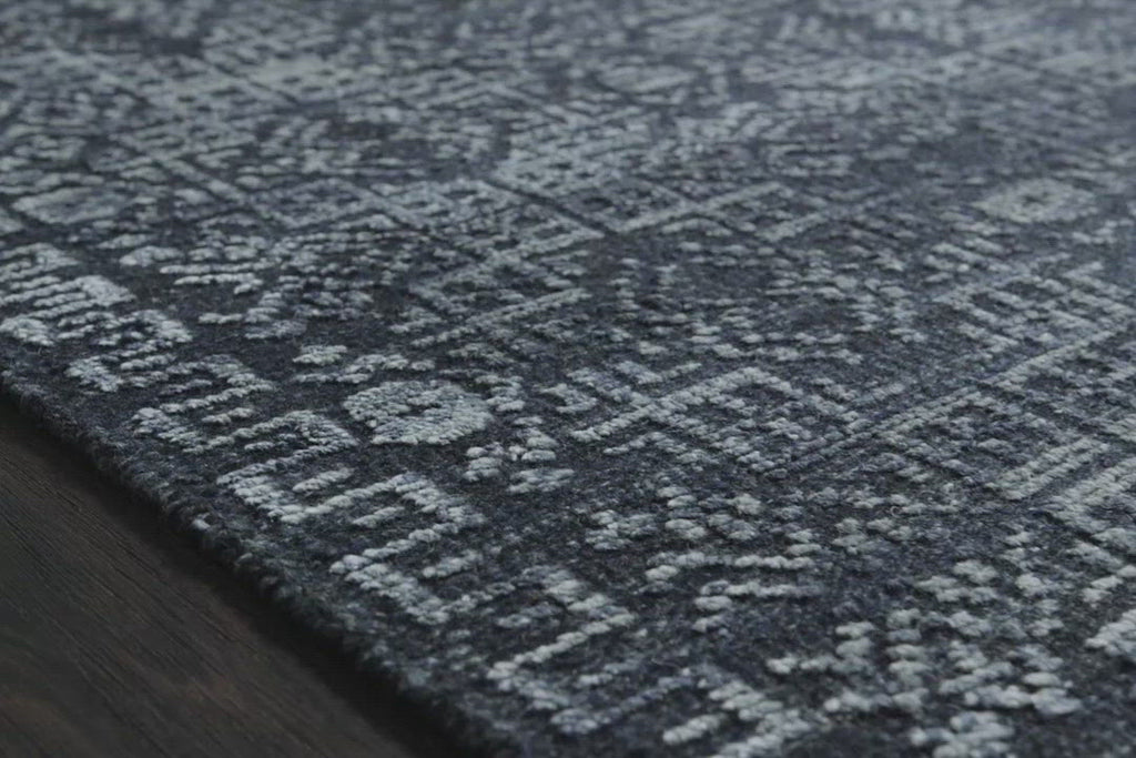 The Idris Ink area rug from Loloi is meticulously hand-knotted of viscose and wool. You will love this rug because the rug is:  Perfect for entryways, living rooms, and bedrooms Easy to clean and maintain Gorgeous with the intricate pattern and patina Warms up any room with the high / low pile Hand-Knotted 70% Viscose | 30% Wool ID-03 Ink