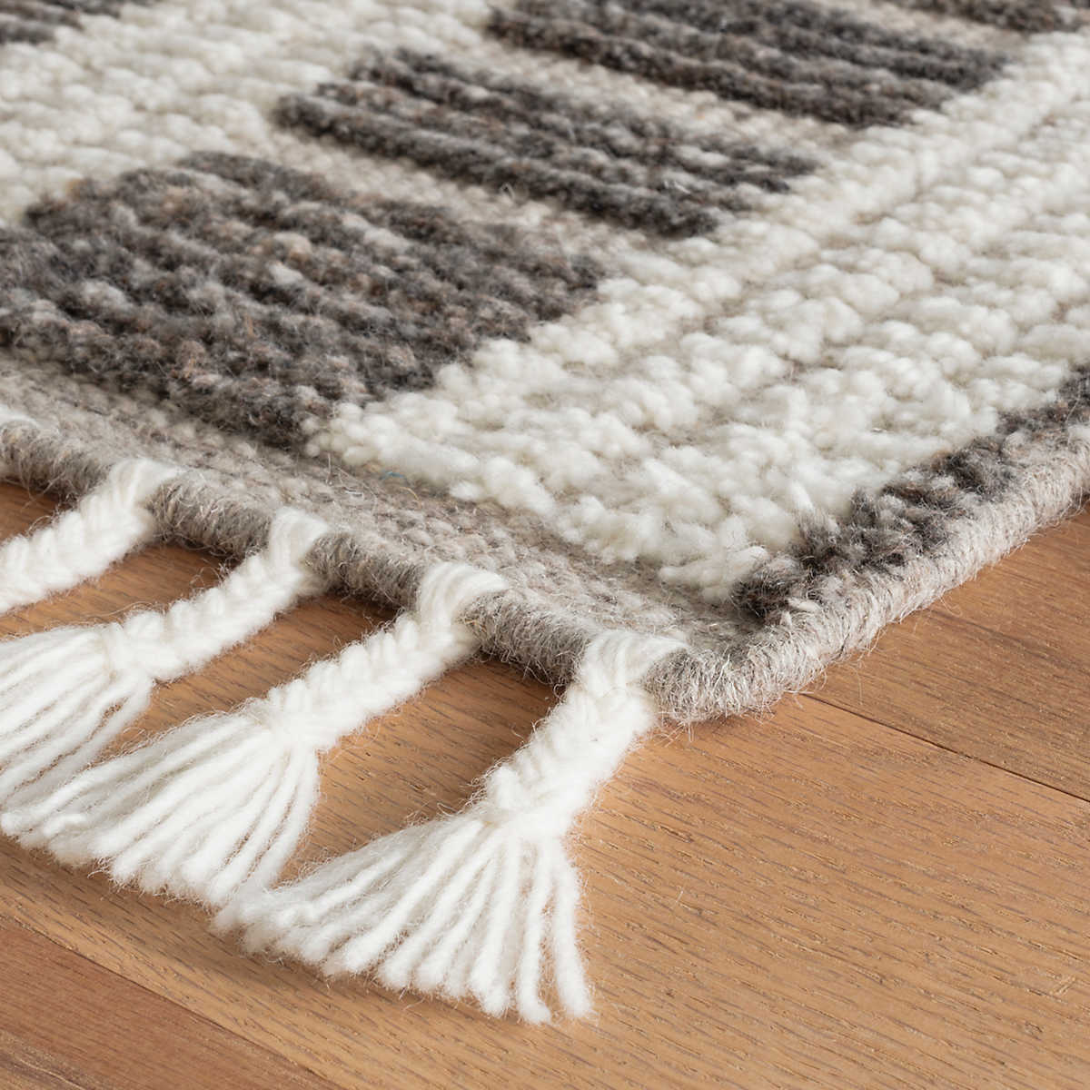 The Tory Grey/Ivory Rug stripes of Ivory fleece alternate with raised bands of naturally colored, mélange Charcoal wool. Interspersed by low-profile, woven taupe boundaries that bring rhythm to the textural blocks. Length sides are lightened with funky, bohemian braided tassels that add whimsy. Amethyst Home provides interior design services, furniture, rugs, and lighting in the Kansas City metro area.