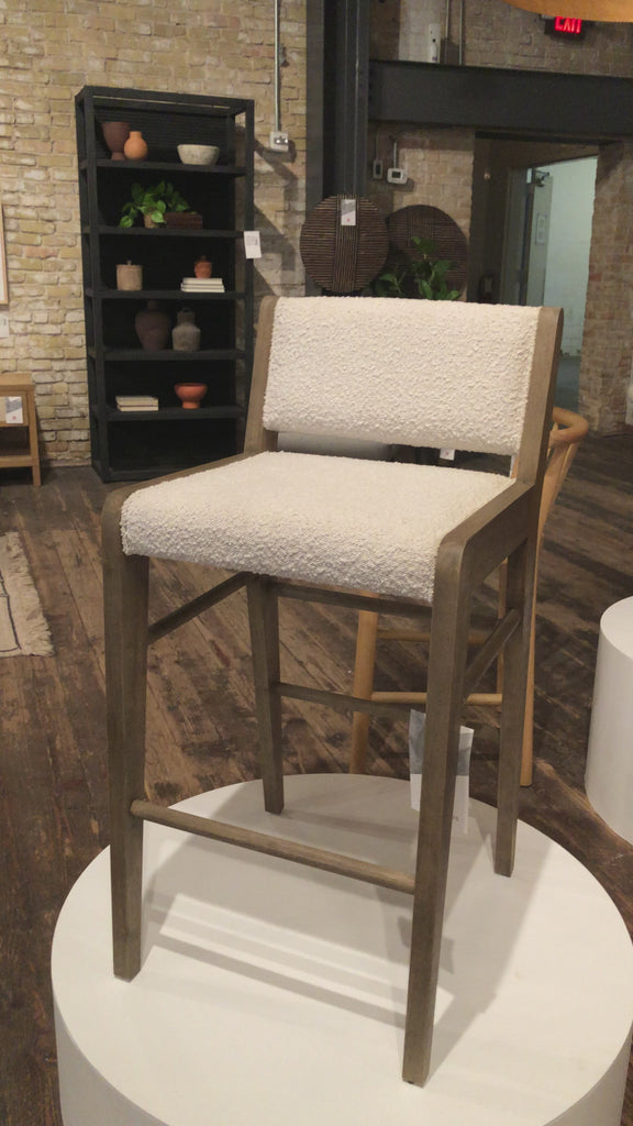 We love the mixed materials found in this Charon Bar + Counter Stool. In a light, natural finish, solid parawood forms an angular frame for boucle-upholstered seating in a classic cream.