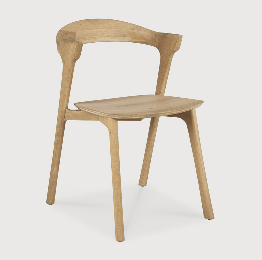 This Oak Bok Dining Chair features an airy shape with rock-solid construction,  making this piece a timeless and remarkable design to enjoy for years to come. Pair with a dining table or stand-alone against a wall, hallway, or end of the bed! Designed by Alain can Havre  Dimensions: 20"w x 21.5"d x 30"h  Weight: 20 lbs  Seat Height: 18"  Material: Oak, 100% solid wood Finish: Oiled