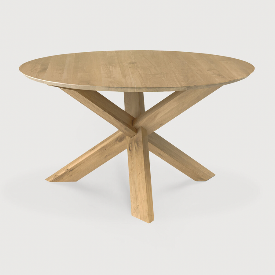This Oak Circle Round Dining Table is all about inspiring your family to spend a little more time at the table. The solid legs intertwine in perfect balance to create a unique, bright look to any kitchen or dining area.   Material: Oak, 100% Solid Wood Finish: Varnished