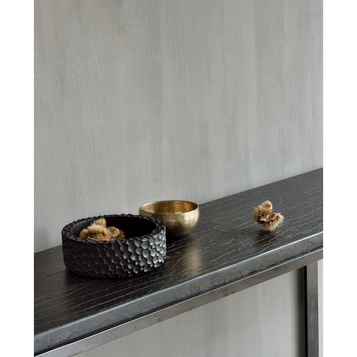 The deep surface of the Stability console is shaped by hand by skilled artisans. Natural mineral powders and color pigments blend to form the console's unique finish. We love how this piece's simple lines showcase the clean beauty of well-crafted metal work. We imagine this unique piece in your entry hall or behind your sofa.  Dimensions: 67"w x 16"d x 30"h  Weight: 30 lbs  Material: Minerals Finish: Metallic 