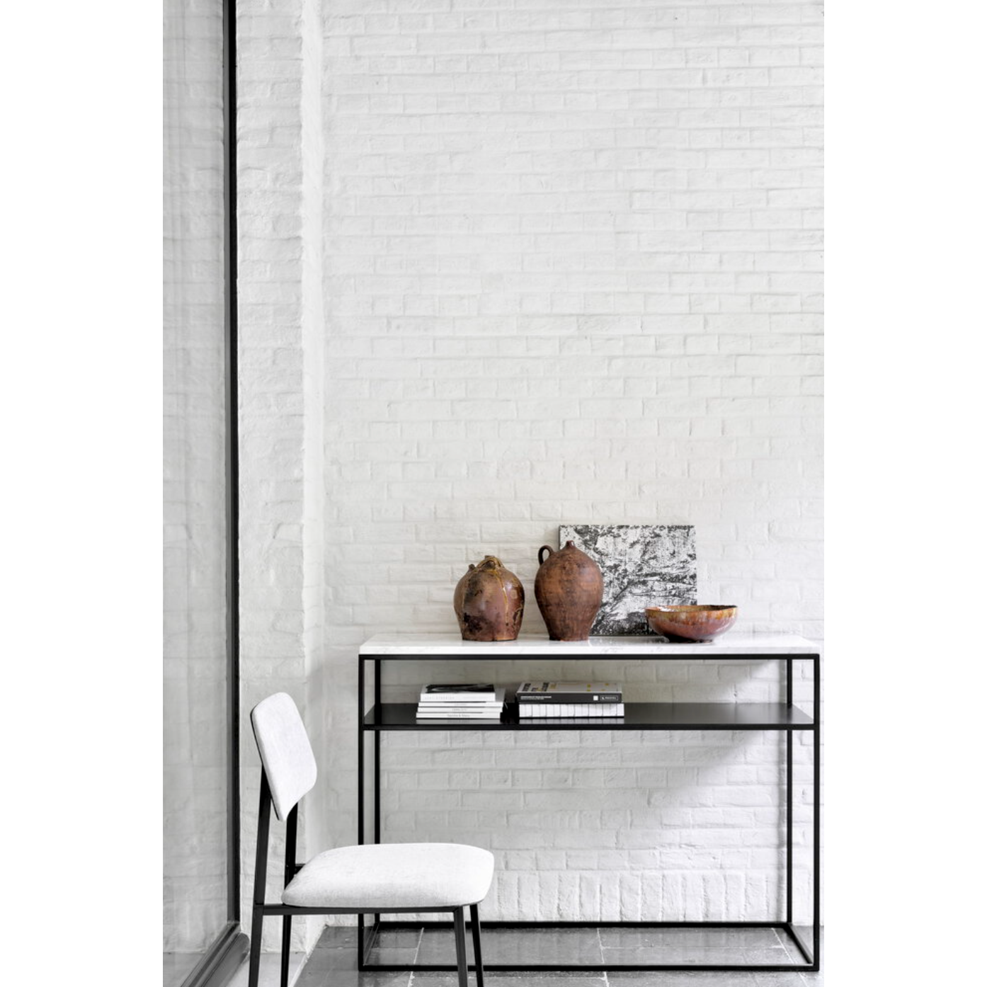We love that the Stone console is an even mix of contemporary and glamorous elements bringing a touch of chic style to your entry way or living room. With its modern open metal frame and its pristine marble, we admire the simple lines and sleek design by designer, Djordje Cukanovic.  Dimensions: 47.5"w x 16"d x 34"h  Weight: 91 lbs  Material: Marble top, black metal frame