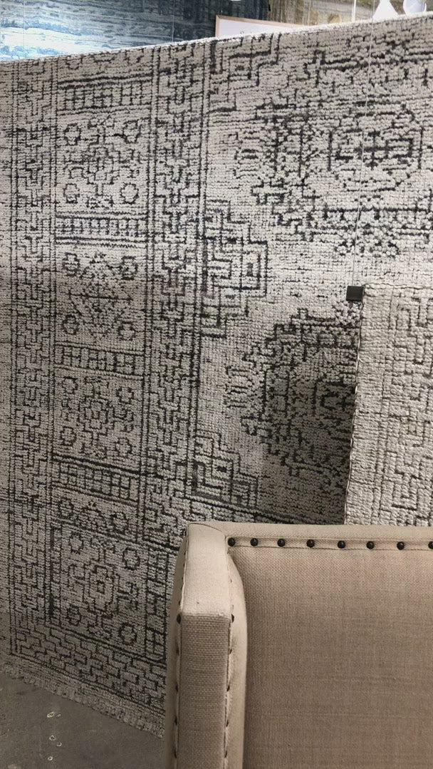 Hand-knotted in India of viscose and cotton, the Vestige White / Black Area Rug recalls ancient khotan rugs in an updated color palette. Soft underfoot, the silken yarns temper the graphic motifs to create a versatile foundation.  Hand Knotted 89% Viscose | 11% Cotton VQ-01 White / Black