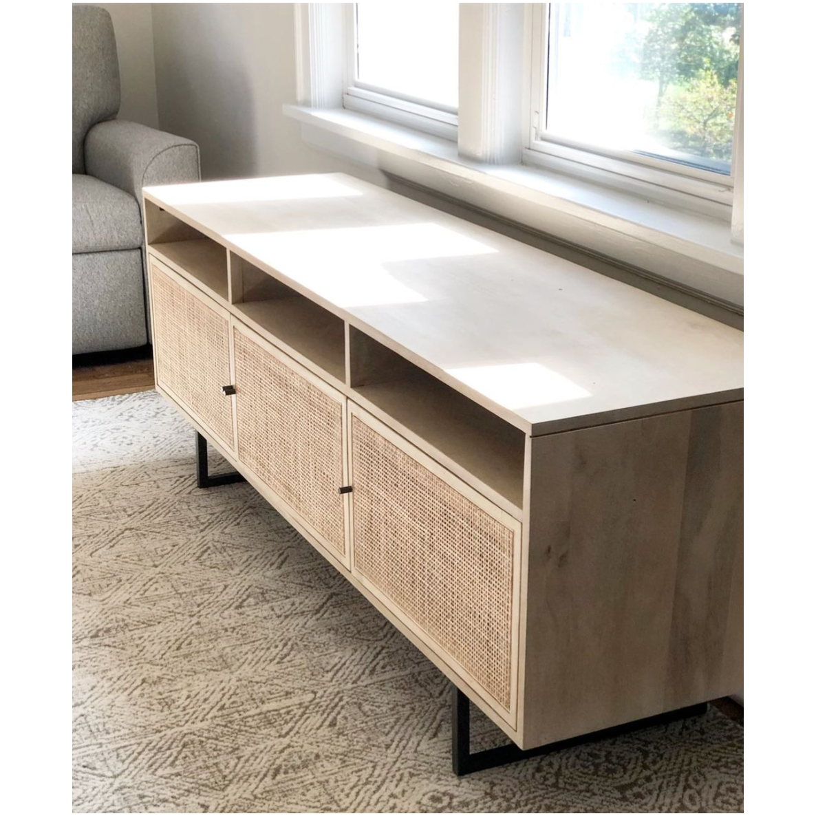 We love the organic feel of this Carmel Natural Mango Media Console. The shelves and posterior cord management make this the perfect media console for families wanting extra storage, while also adding a mid-century look to the room.   Size: 65"w x 18"d x 24"h  Materials: Mango Wood, Cane, Iron