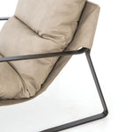 Super stylish, effortlessly cool - this Emmett Sling Chair - Umber Natural has light leather that sits low and curved for a fresh take on a throwback form. Slim, gunmetal-finished iron framing elevates the space for any living room or lounge area.   Overall Dimensions: 29.00"w x 36.00"d x 29.00"h