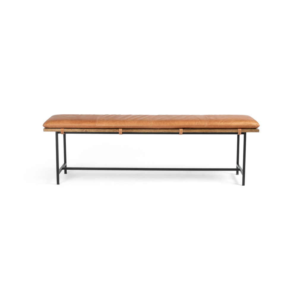 Airy, black-finished iron legs support a nettlewood dining bench of a chic, comfy layer of brandy top-grain leather on this Gabine Accent Bench - Brandy. A handsome piece to add to any bedroom, living room, or entryway.   Overall Dimensions: 72.00"w x 18.00"d x 22.00"h