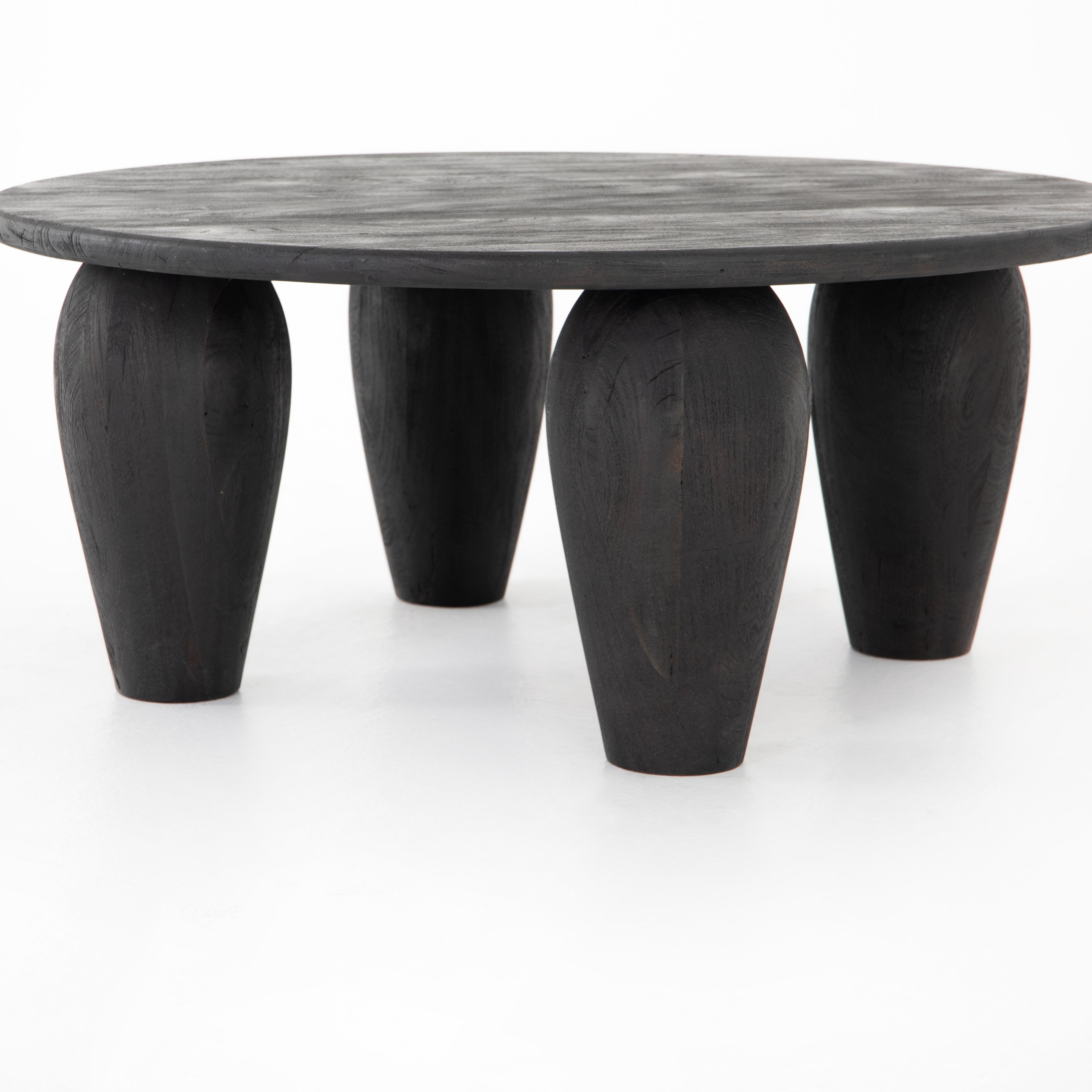 We love the shapely, substantial legs that support a slim, rounded tabletop of light black-finished reclaimed woods in this Maricopa Coffee Table - Dark Totem. A global, organic look with a handcrafted vibe.
