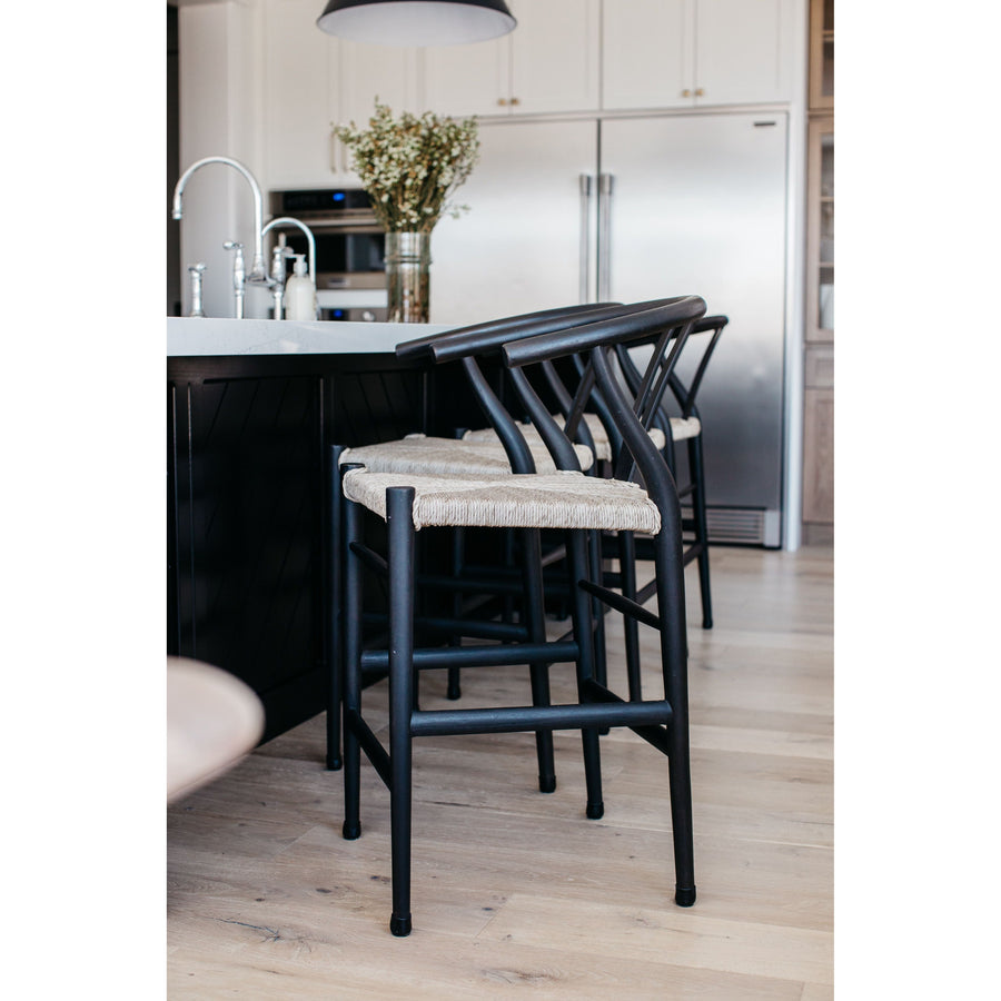 Modern curves redefine the classic wishbone-style of this Muestra Black Teak Counter + Bar Stool. Vintage white all-weather wicker is woven for a dose of fresh texture within weathered grey teak framing. Cover or store indoors during inclement weather and when not in use.