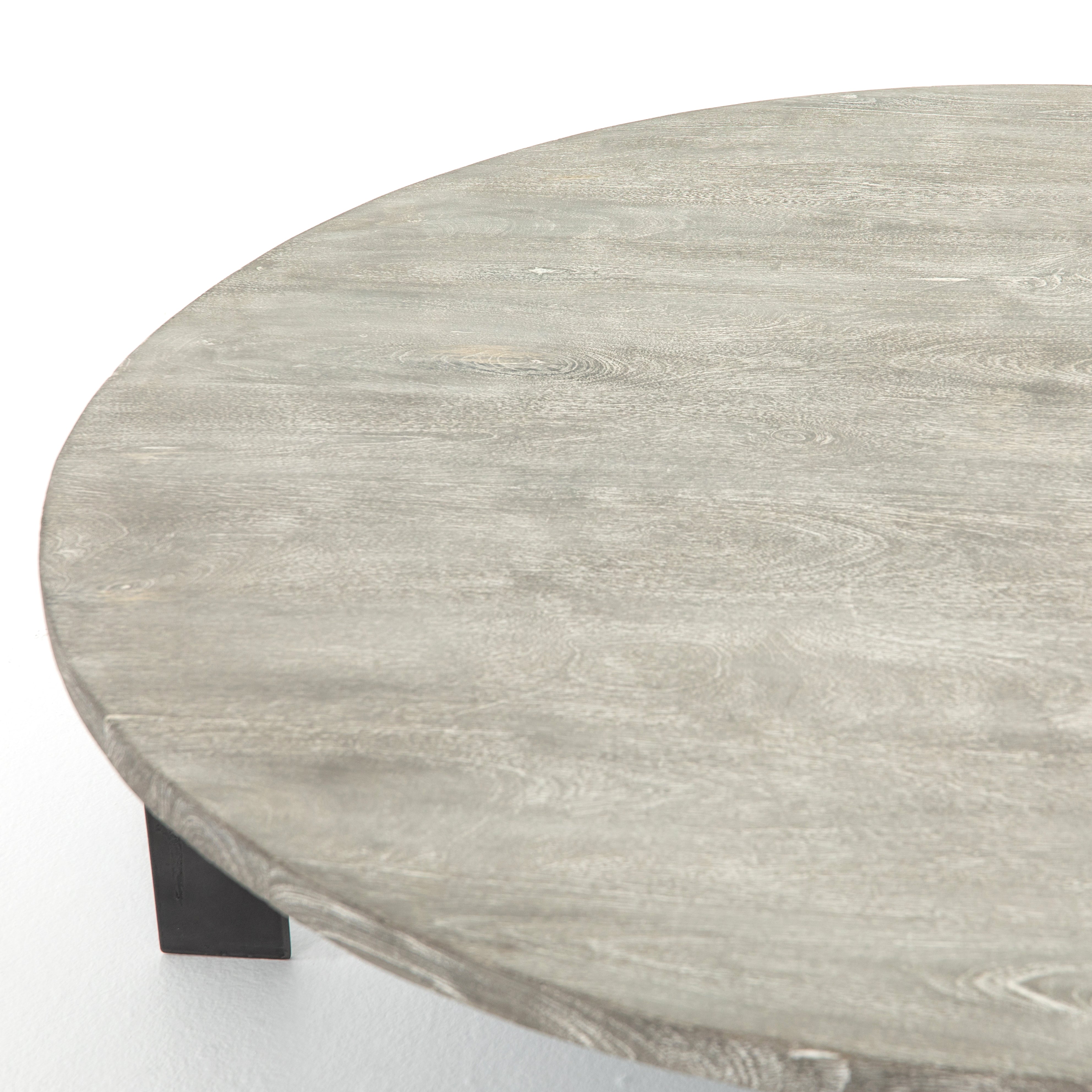 We love the thin iron gunmetal legs of this Round Coffee Table with Iron. The charcoal tones bring a neutral tone to any living room or lounge area.   Overall Dimensions: 48.00"w x 48.00"d x 15.50"h   Colors: Gunmetal, Charcoal Materials: Iron, Mango Wood Weight: 75.51 lb