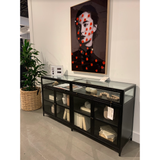 This Shadow Box Sideboard gives your inner collector a place to play. Store prized possessions behind clear glass fronts, with black-finished metal casing and brass hardware for contrast.  Overall Dimensions: 70.00"w x 17.25"d x 35.00"h