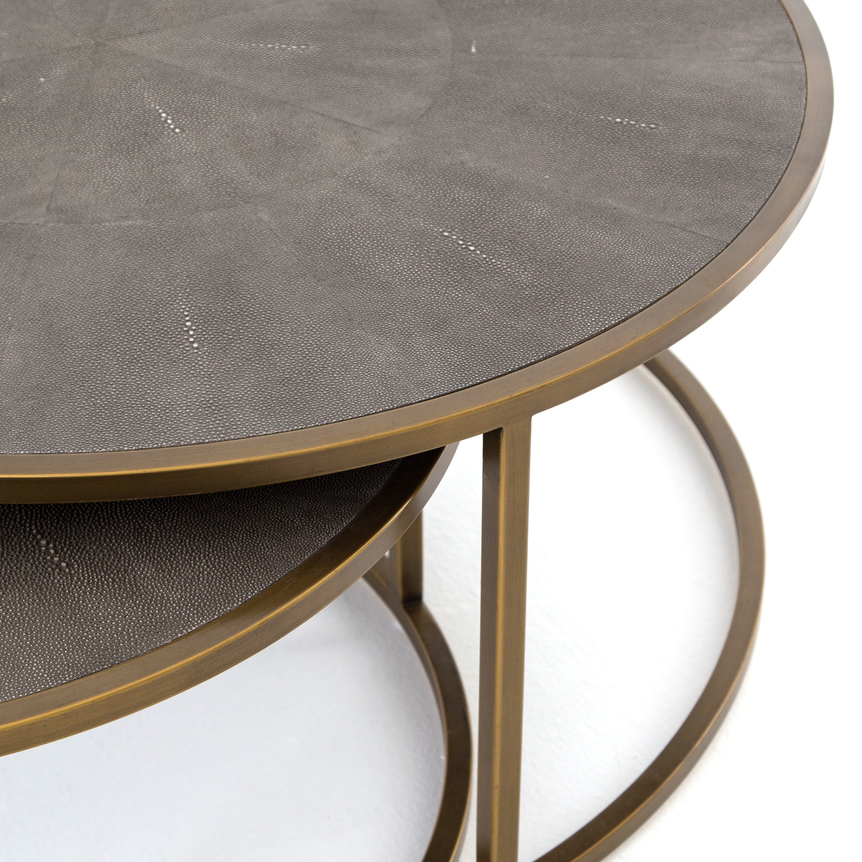 Antique brass-finished iron curves like a crescent to welcome a nesting option for its smaller-scaled companion table with this Shagreen Nesting Coffee Table - Grey. A resin faux shagreen table top in grey lends rich texture to clean, modern lines for any living room or lounge area.   Large Table Dims: 38"w x 38"d x 16"h Small Table Dims: 30"w x 30"d x 14"h Overall Dimensions: 38.00"w x 38.00"d x 16.00"h