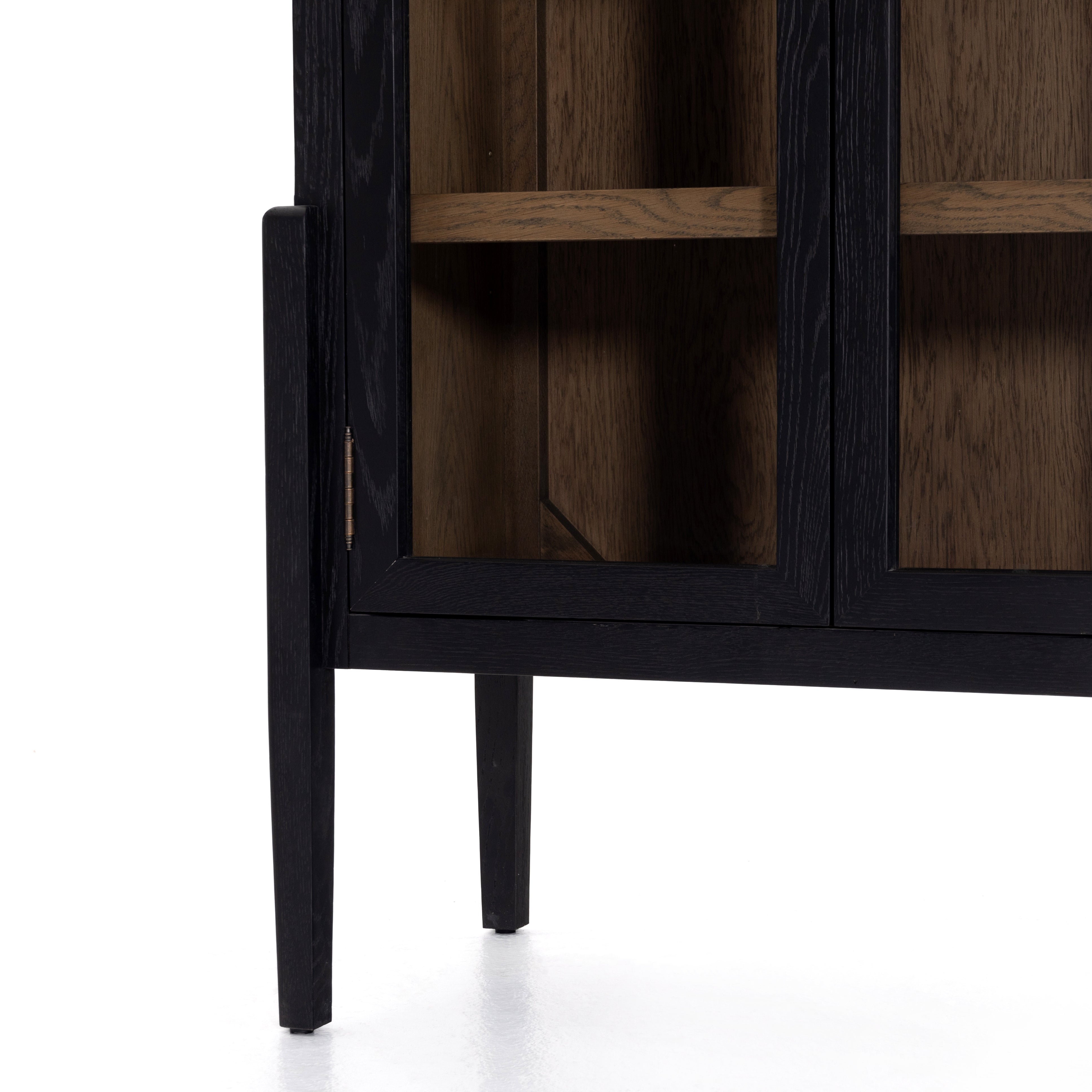 Store it in style with this Tolle Cabinet - Drifted Oak. Beautifully shaped cabinetry of black solid oak features spacious interior shelving and clear glass front, ready for displaying favorite books, photos and treasures in any room!  Overall Dimensions: 38.00"w x 19.00"d x 84.00"h
