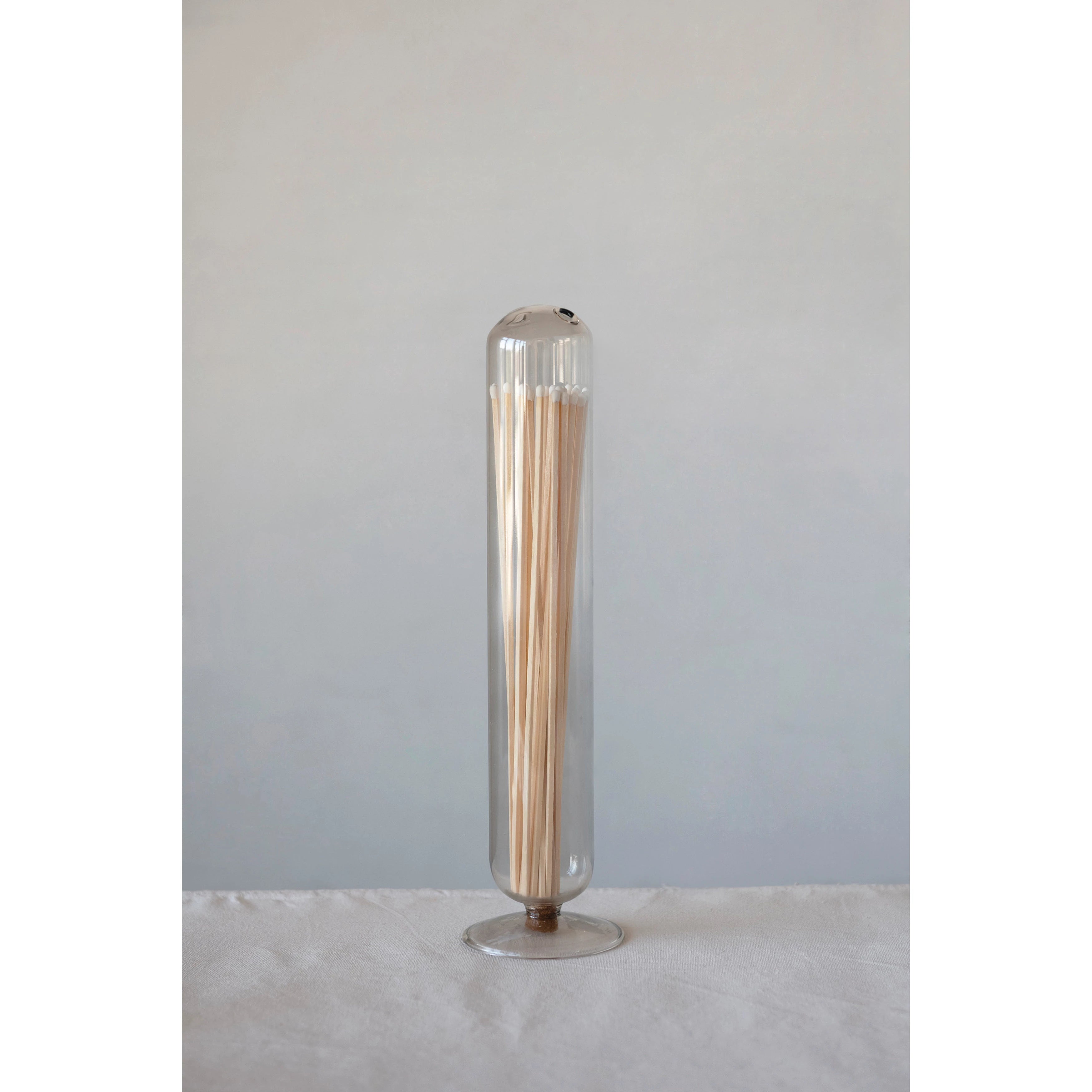 This Glass Match Holder is the perfect home for extra long match sticks — place next to all your candles or fireplace for easy access.  Size: 3.5" Round x 13.75"H